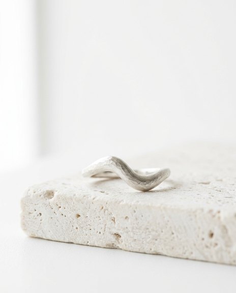 A sculptural silver ring representing the design process